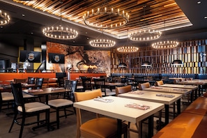 A restaurant interior with multiple dining tables, chairs, and a modern ceiling design. - Harrah's Council Bluffs Hotel & Casino - A Caesars Rewards Destination (Council Bluffs)