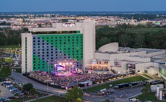 A large hotel with a central stage and a crowd gathered in front.