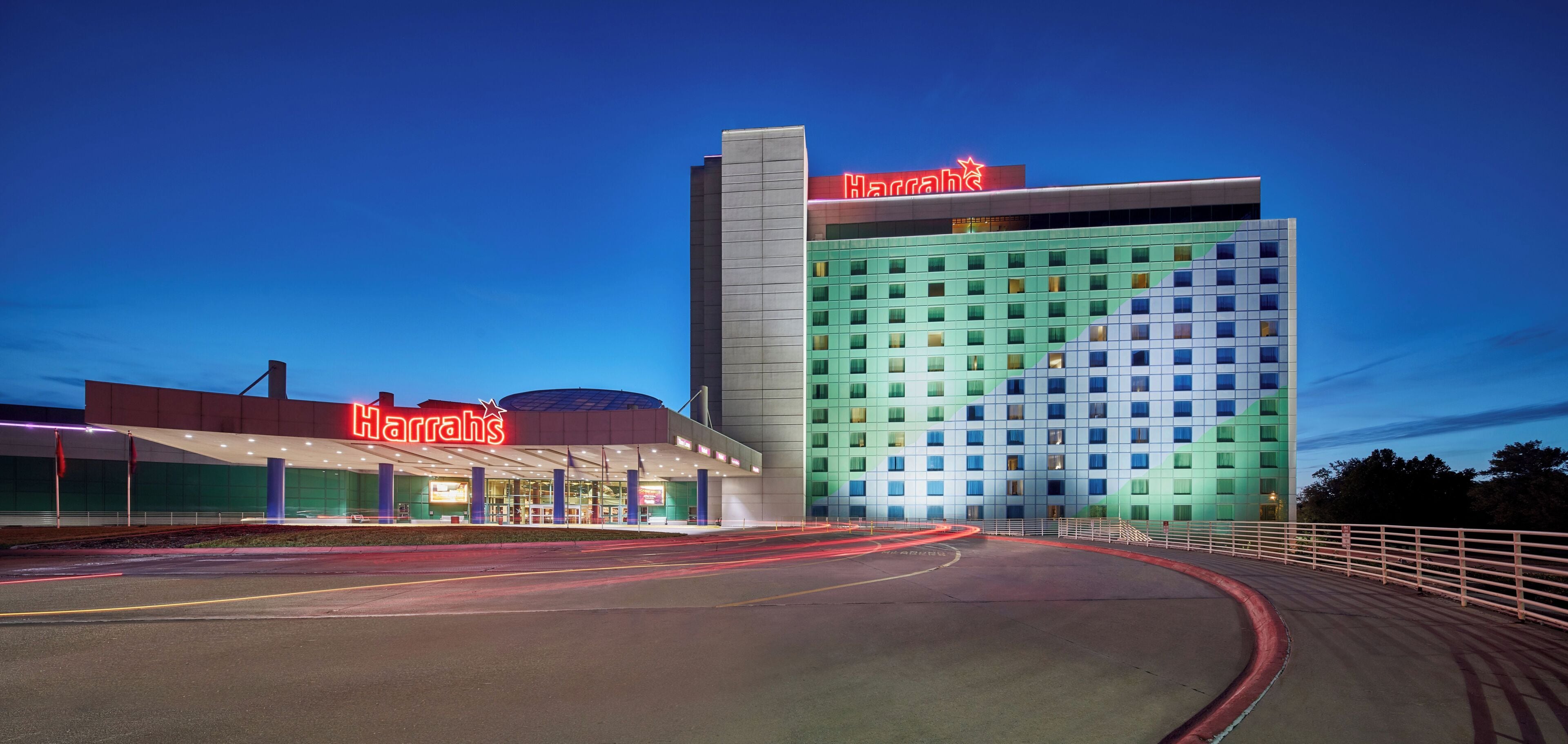 Un hotel modern de Harrah's amb un cartell de neó destacat, un pàrquing ampli i una façana arquitectònica característica.