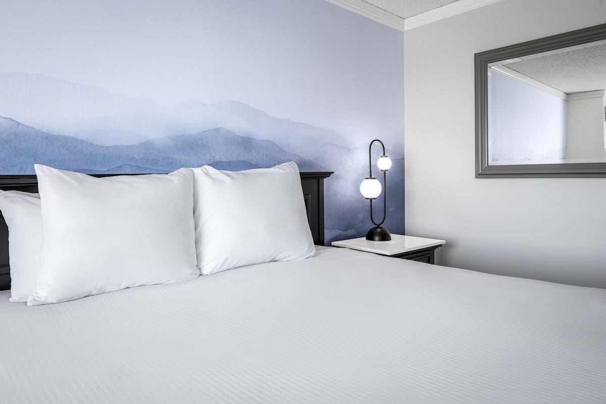 deluxe room, 1 king bed, non smoking | premium bedding, in-room safe, laptop workspace, blackout curtains
