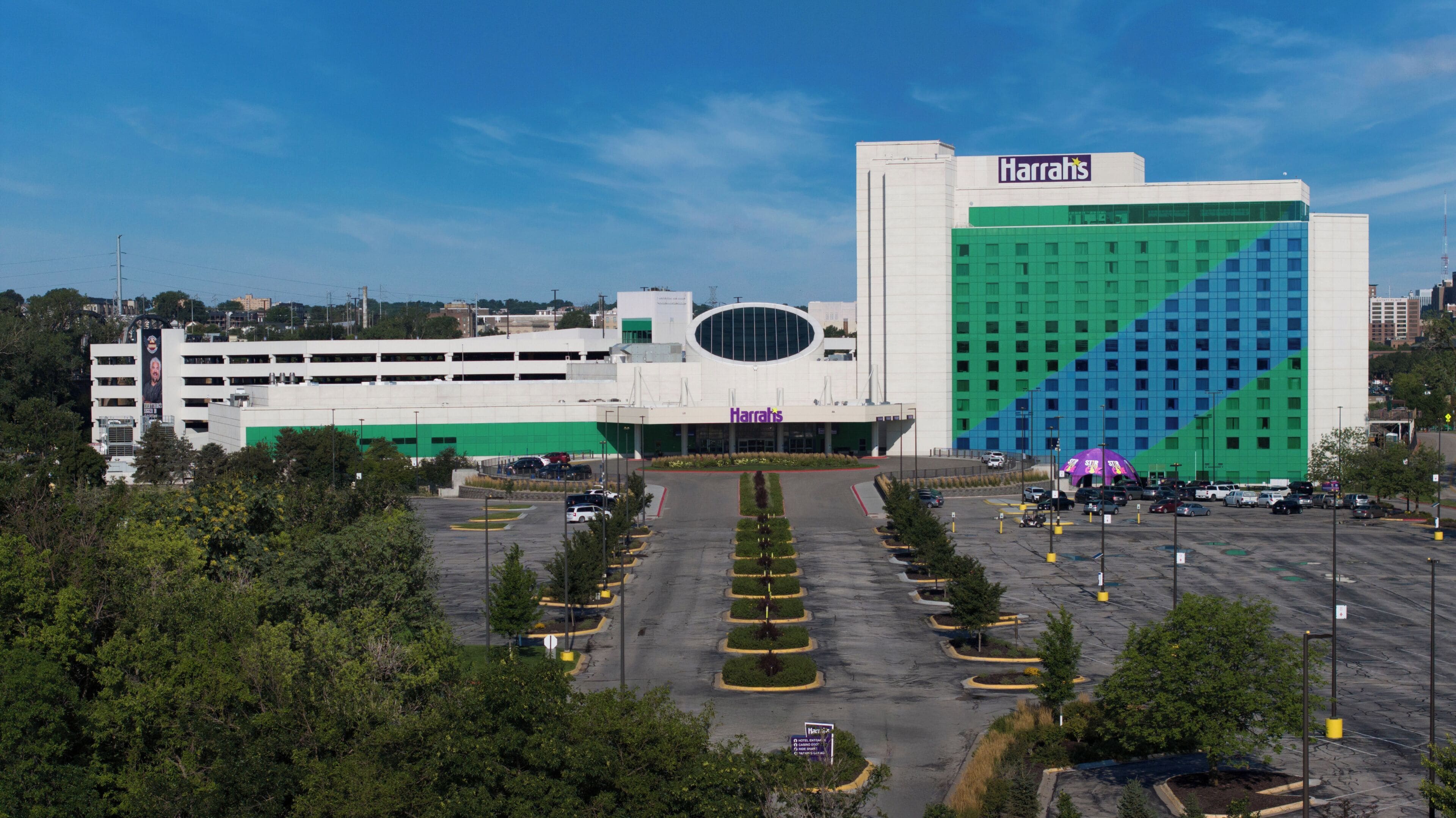 A large Harrah's casino building with a parking lot in front.