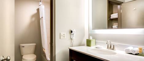 A bathroom with a toilet, a sink, a mirror, and a towel rack.