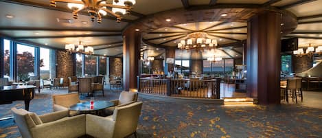 A spacious lobby with a grand chandelier, comfortable seating, and a bar area.
