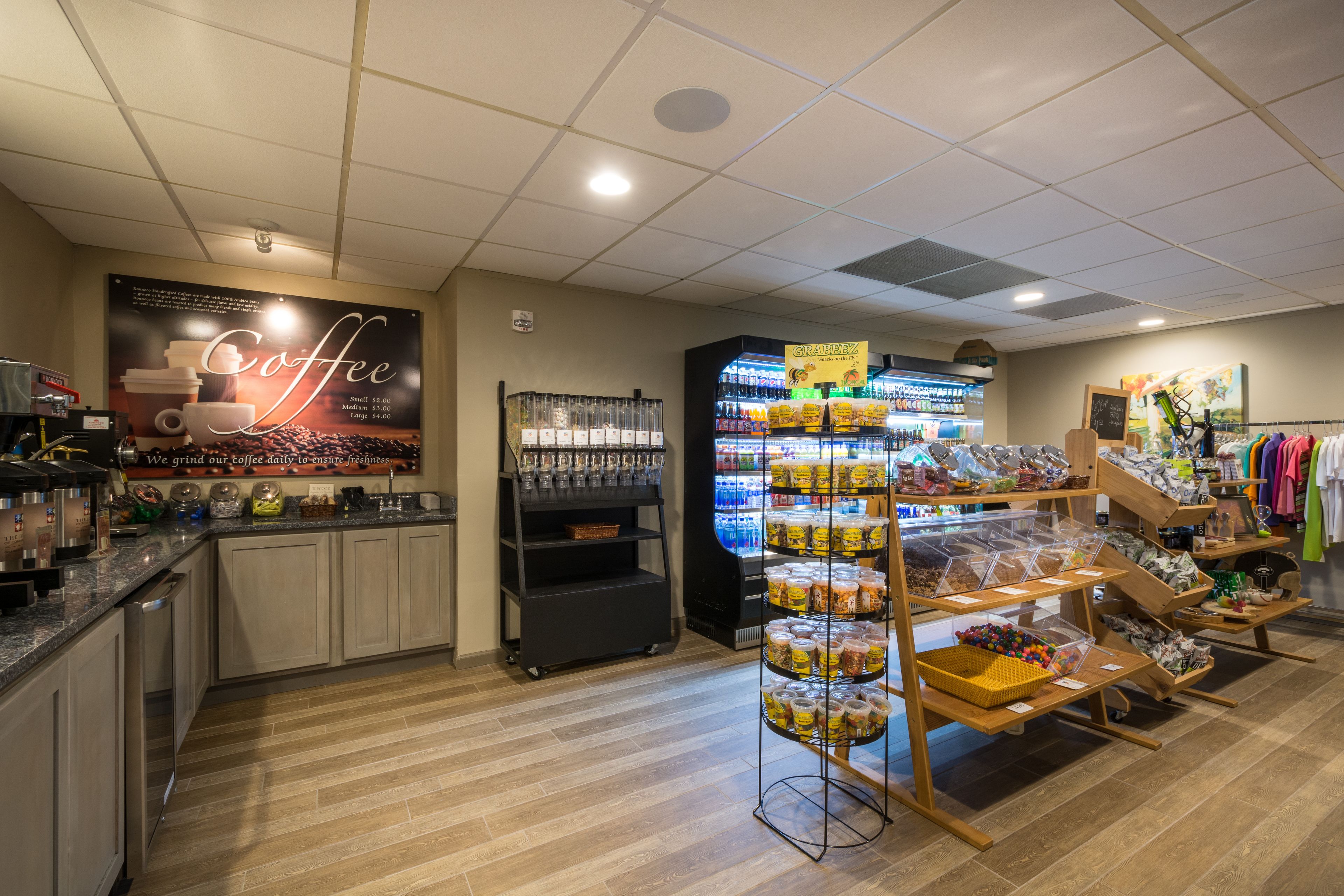 Ein Café-Interieur mit einer Kaffeemaschine, Regalen voller Kaffeebohnen, einer Kühltruhe und einem Kleiderständer.