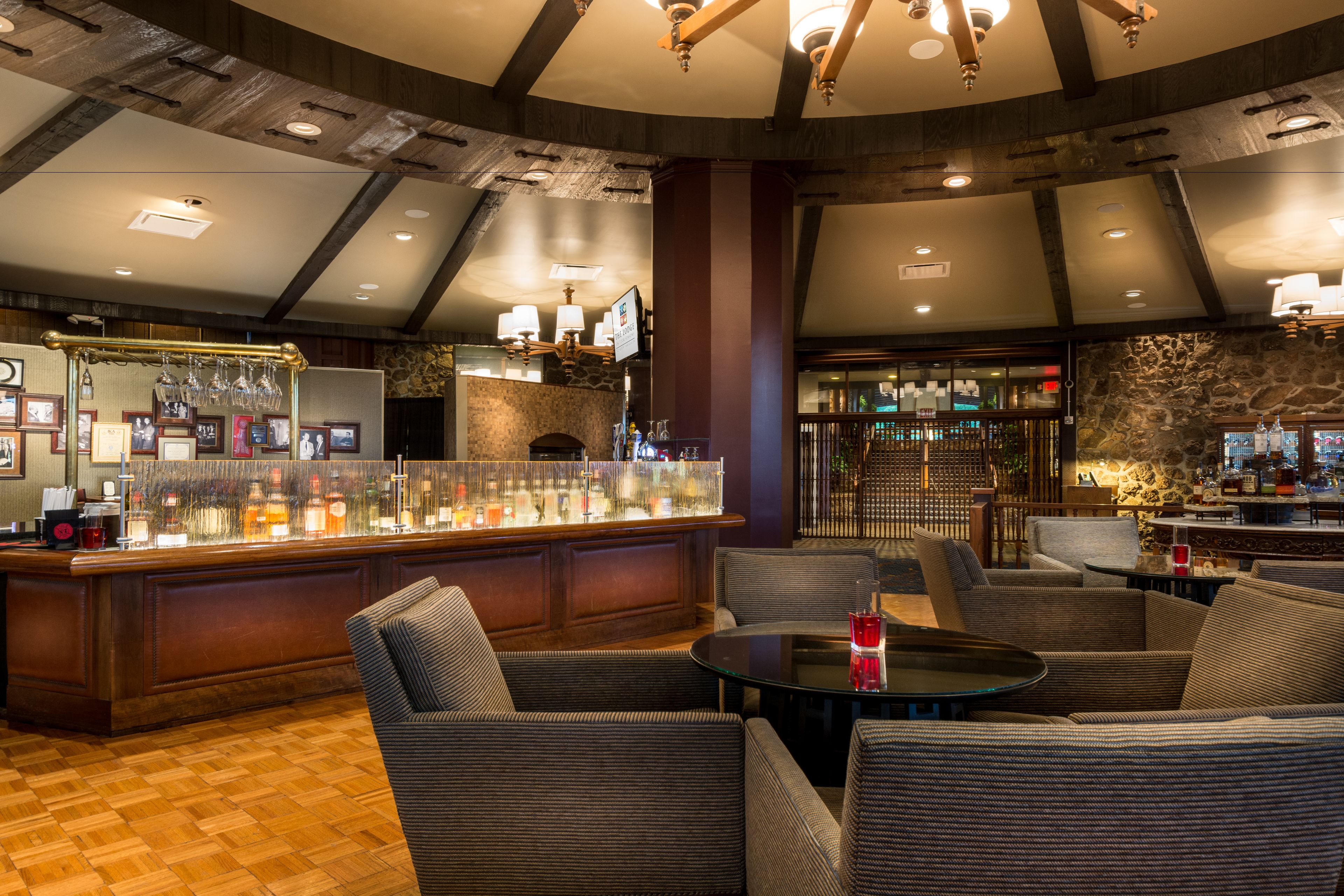 Un’area bar con posti a sedere, una parete in pietra e un soffitto in legno.