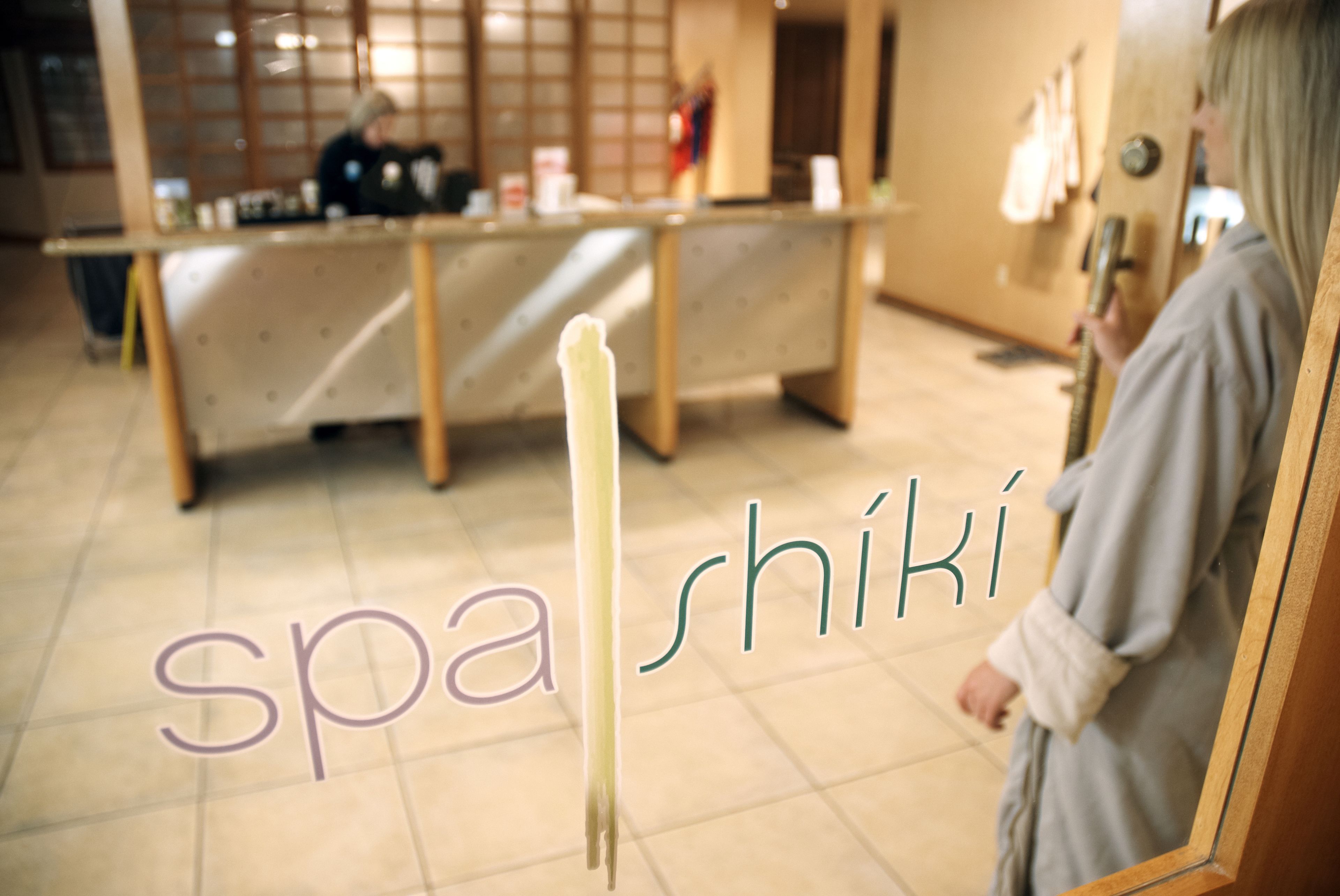 Un spa con mostrador de recepción, perchero y espejo.