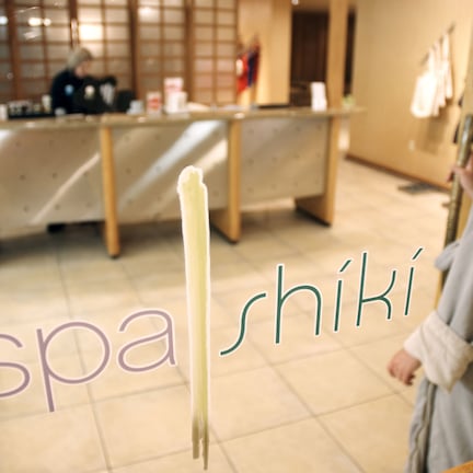 A spa with a reception desk, a towel rack, and a mirror.