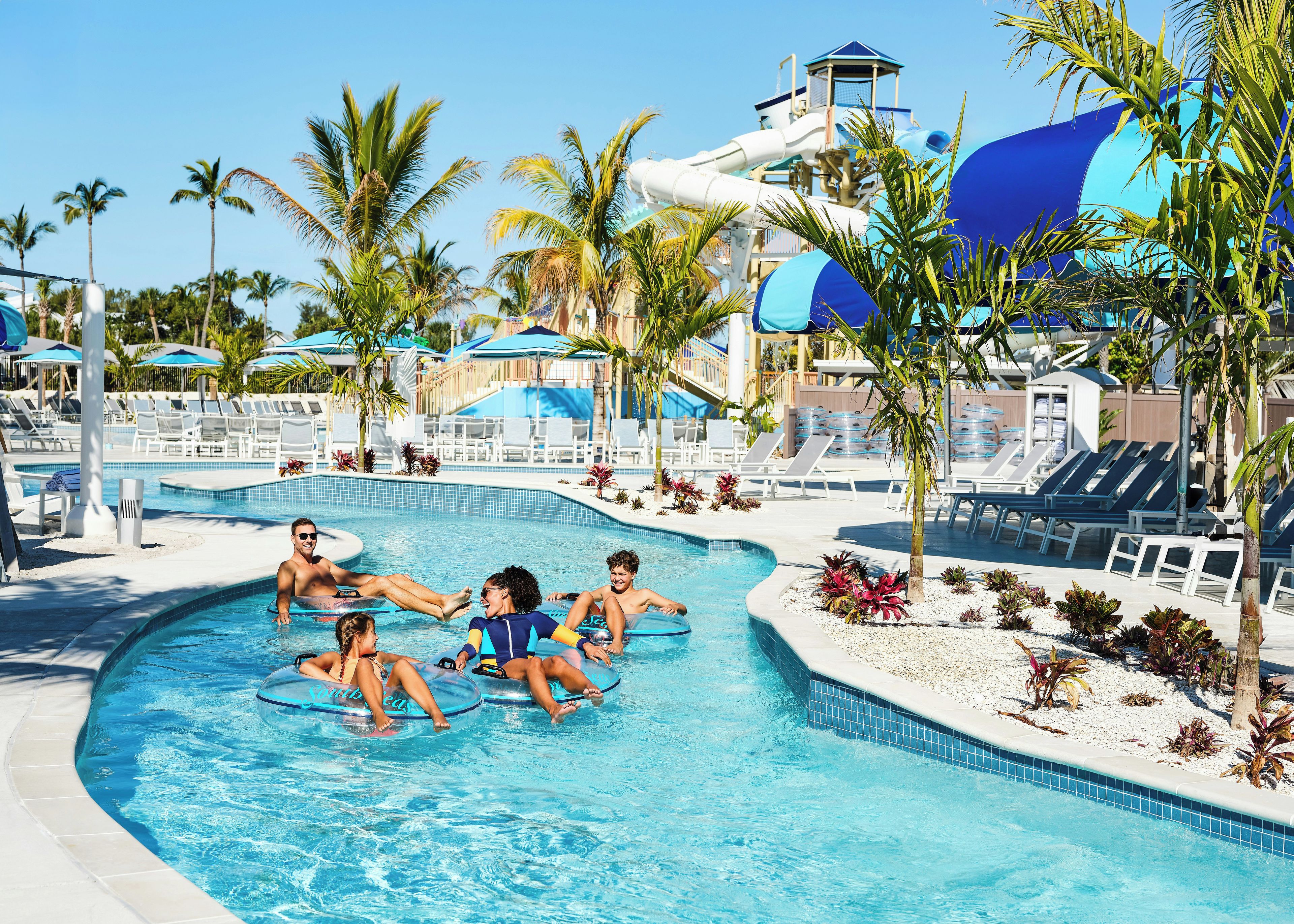 A pool area with lounge chairs and palm trees.