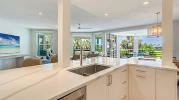 A modern kitchen with a large island, built-in appliances, and a view of the outdoors.
