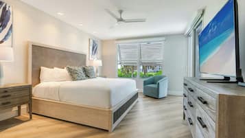 A modern bedroom with a bed, nightstands, a dresser, a television, and a ceiling fan.