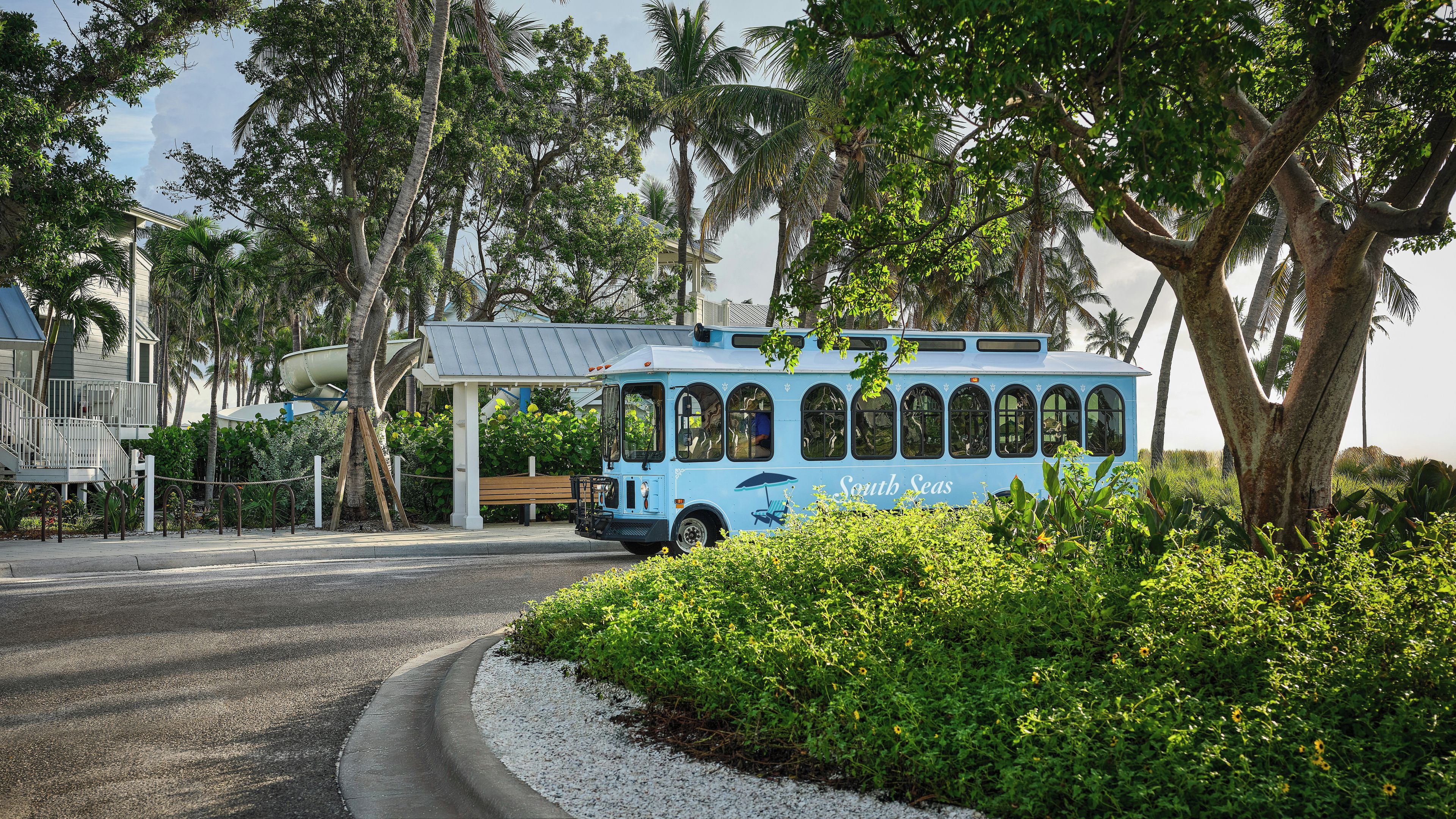 Ein blauer Bus mit der Aufschrift 'South Seas' steht in der Nähe eines Gebäudes mit einem Vordach.