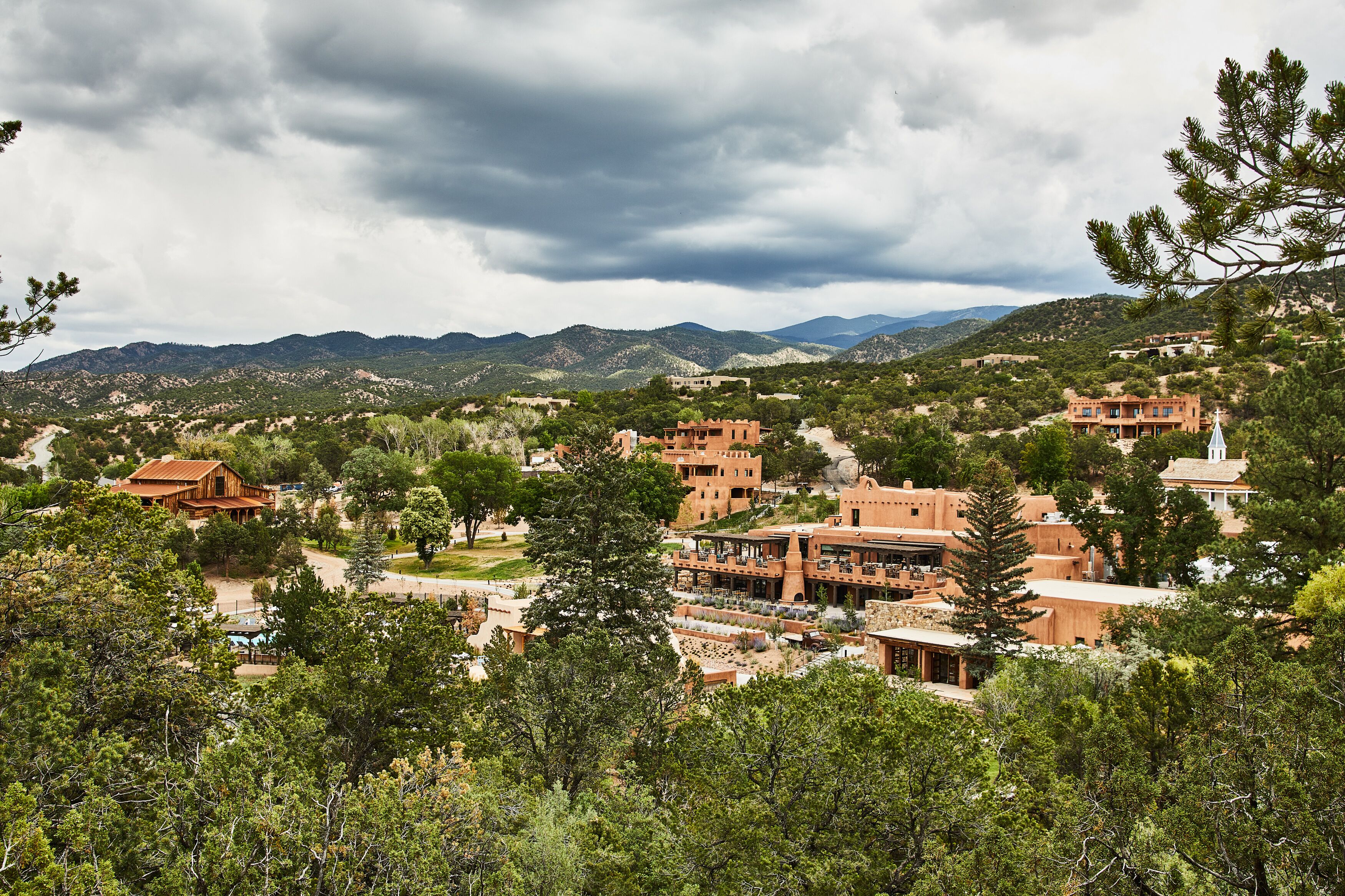A mountainous landscape with buildings surrounded by trees.