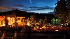 A well-lit outdoor area with seating arrangements and a building with a porch. - Bishop's Lodge, Auberge Collection (Santa Fe)