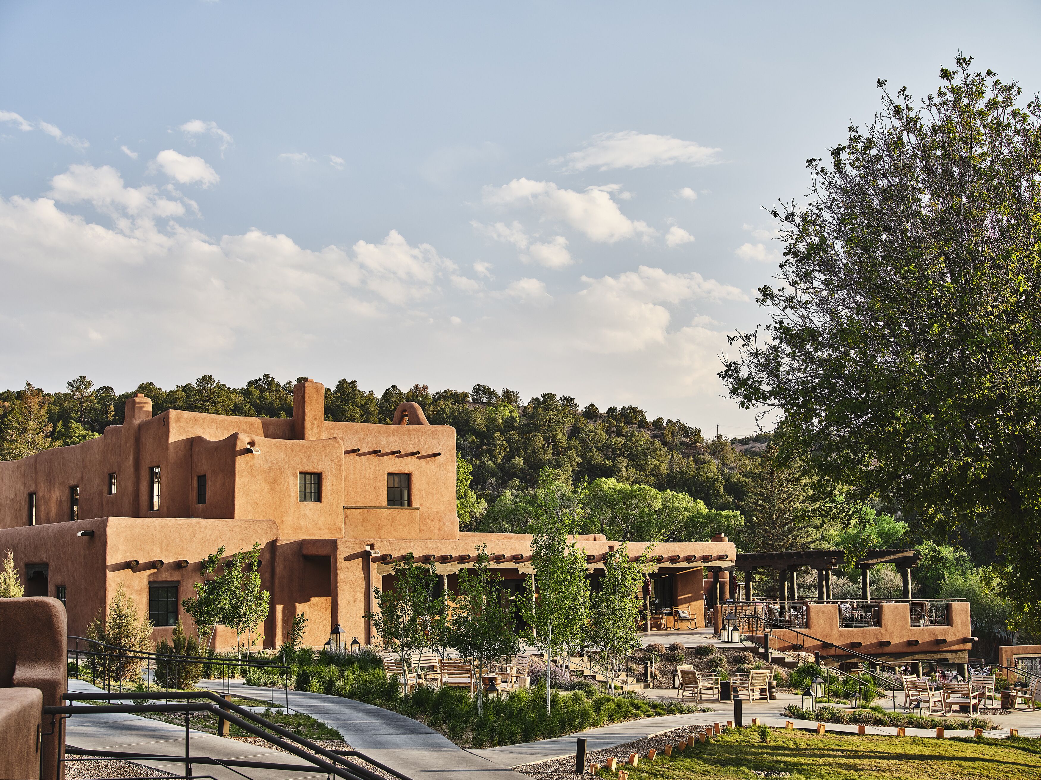 A building with adobe architecture, outdoor seating, and a landscaped garden.