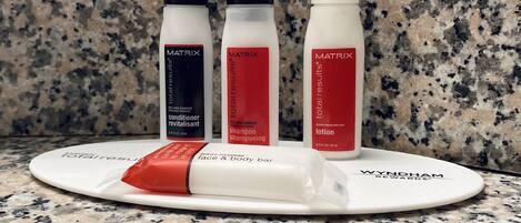 A countertop with three Matrix brand products: conditioner, shampoo, and lotion.