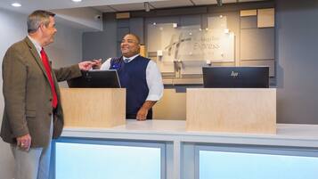A reception desk with a sign indicating a Holiday Inn Express & Suites. There are two computer monitors on the desk.