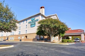 A hotel with a large sign reading "Chesapeake Suites Hilton" and a parking lot in front. - Homewood Suites by Hilton San Antonio Northwest (San Antonio)