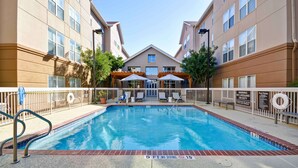 A swimming pool with a lifeguard station, lounge chairs, and a covered seating area. - Homewood Suites by Hilton San Antonio Northwest (San Antonio)
