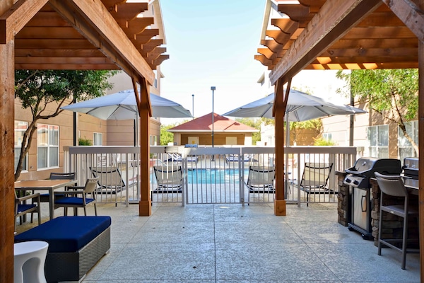 Alberca al aire libre, sombrillas en la alberca y camastros