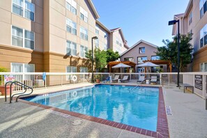 A swimming pool with a lifeguard stand, lounge chairs, and a covered seating area. - Homewood Suites by Hilton San Antonio Northwest (San Antonio)