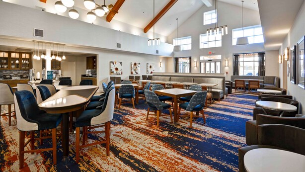 A spacious dining area with high ceilings, exposed beams, and modern pendant lighting. - Homewood Suites by Hilton San Antonio Northwest (San Antonio)