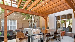 An outdoor patio with a grill, dining table, and chairs. - Homewood Suites by Hilton San Antonio Northwest (San Antonio)