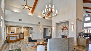 A spacious hotel lobby with a reception desk, seating area, and a fireplace. - Homewood Suites by Hilton San Antonio Northwest (San Antonio)
