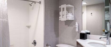 A modern bathroom with a bathtub, toilet, and a vanity with a sink.