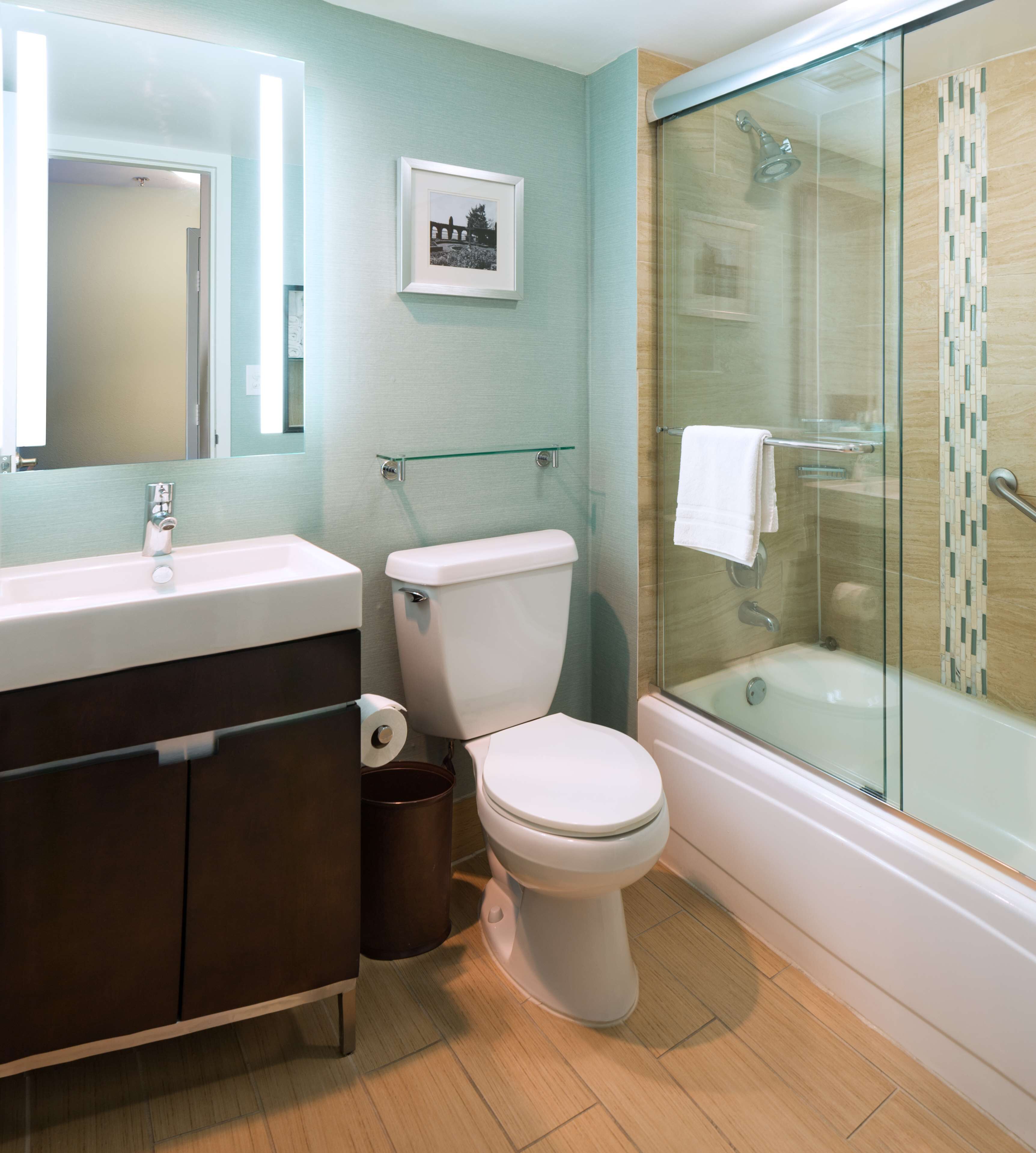 A bathroom with a toilet, sink, and glass-enclosed shower.