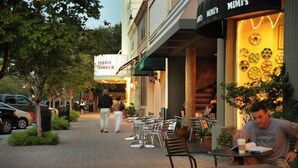 Una calle con terraza al aire libre y un restaurante llamado "TROPIC THUNDER".