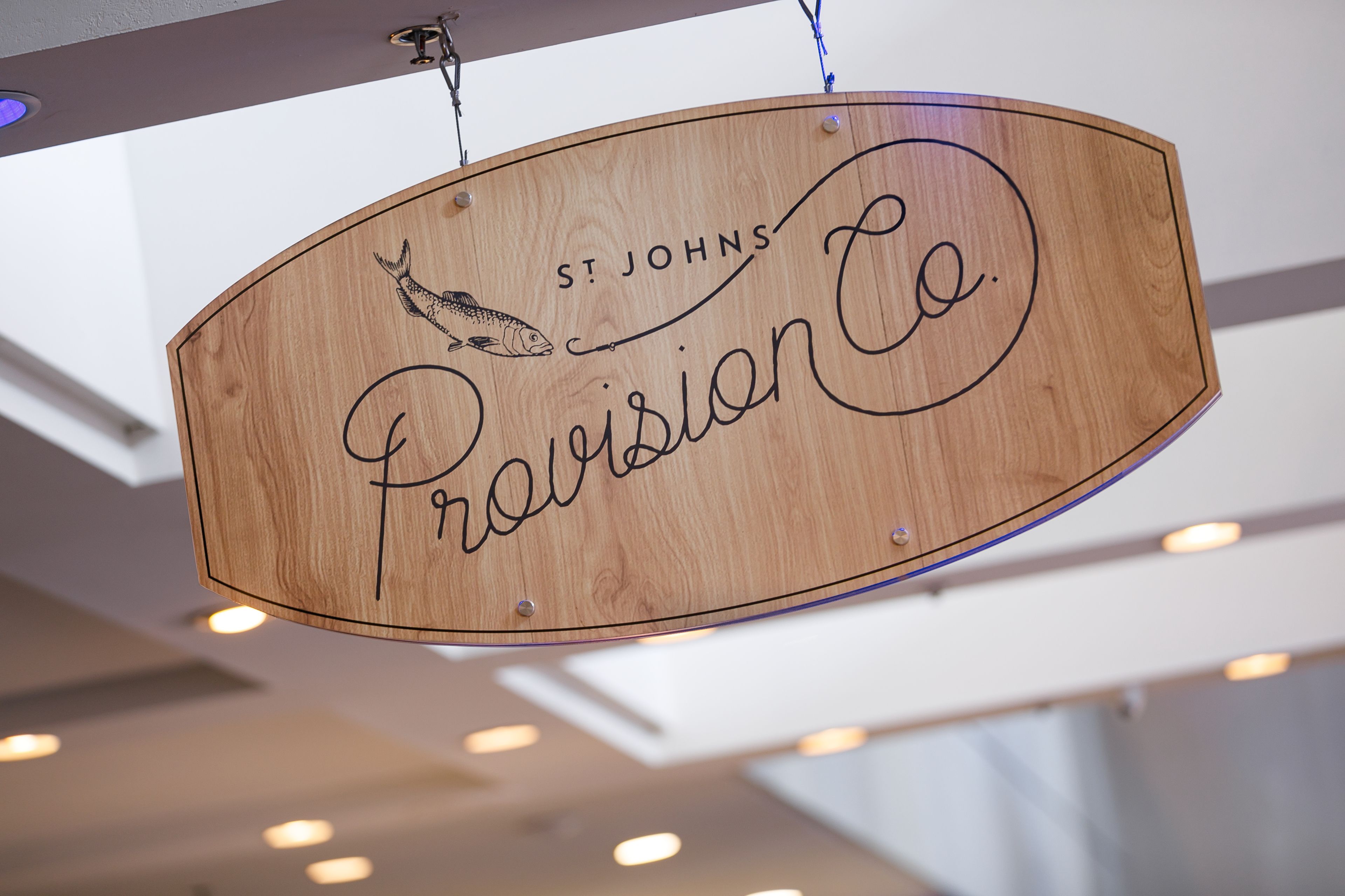 A wooden sign with the text "St. Johns Provision Co." and a fish illustration.