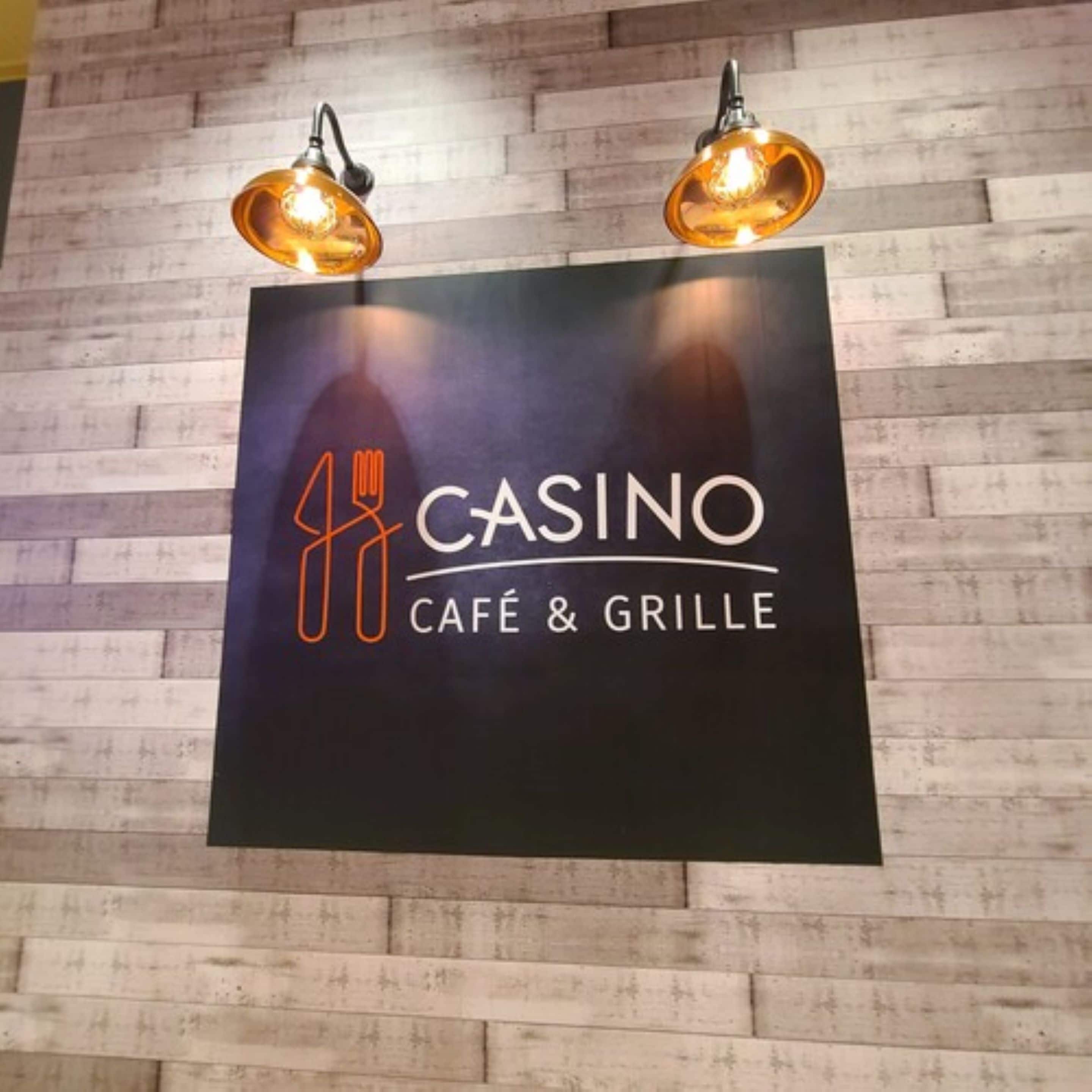 Señal de un café y parrilla de casino con dos lámparas colgantes.