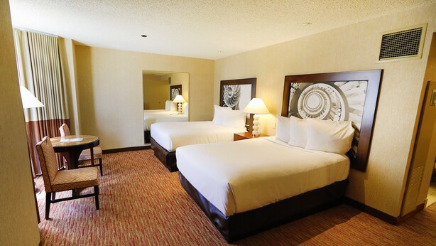A hotel room with two beds, a small table with a chair, and a large mirror. - Bally's Atlantic City Hotel & Casino (Atlantic City)