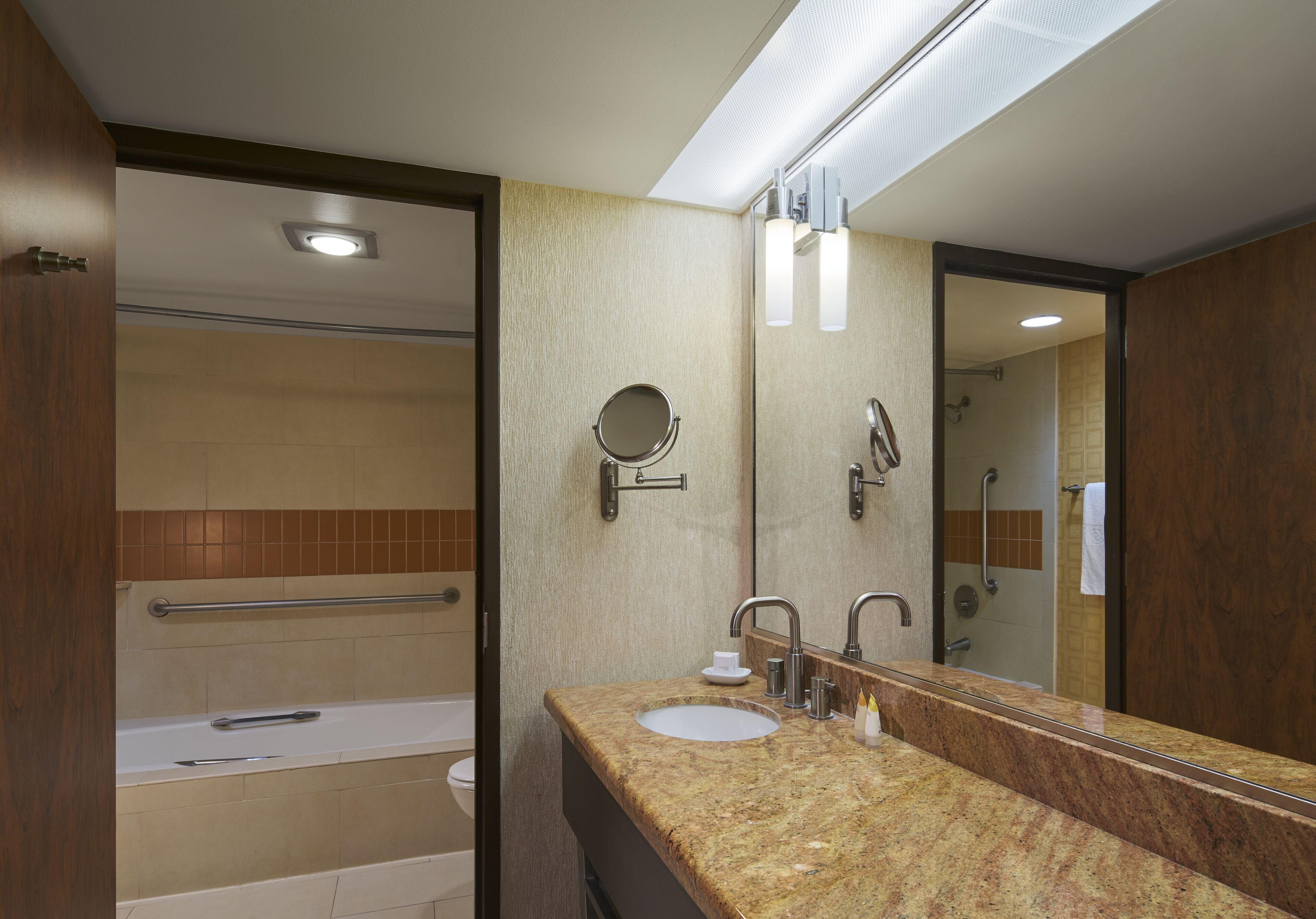 A modern bathroom with a sink, mirror, and shower.