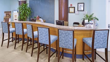 A reception area with a counter, bar stools, and a concierge desk.