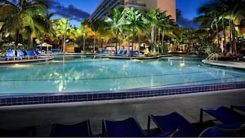 A pool area with lounge chairs and palm trees.