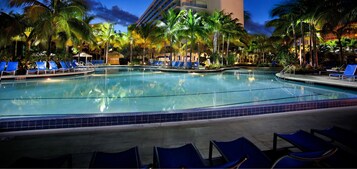 A pool area with lounge chairs and palm trees.
