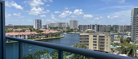 A view of a river with buildings and palm trees.