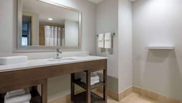 A bathroom with a large mirror, two sinks, and a towel rack.