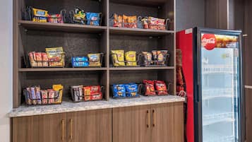 En snackbod med forskellige chips og et Coca-Cola køleskab.