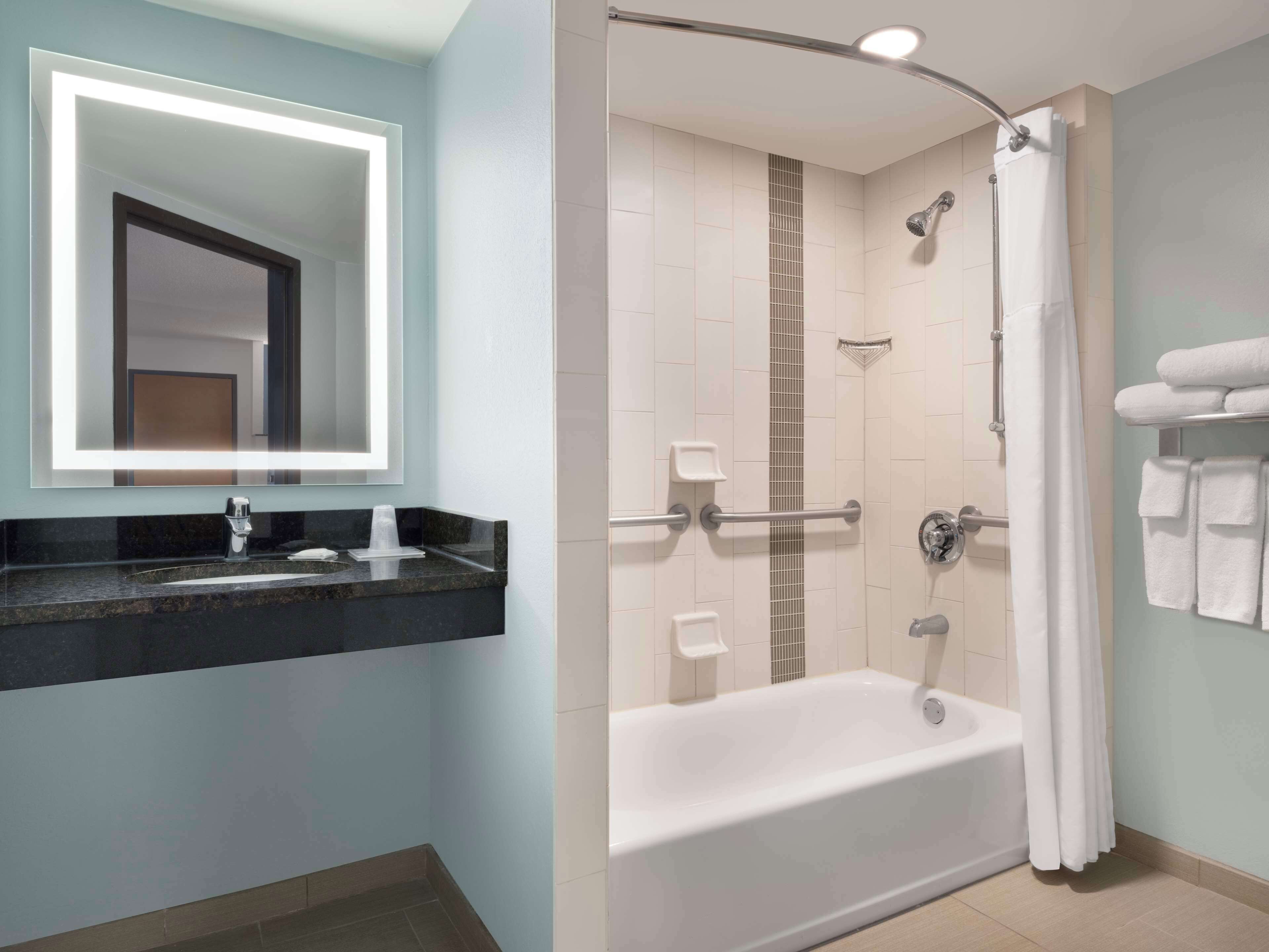 Un baño moderno con tocador, bañera y ducha.