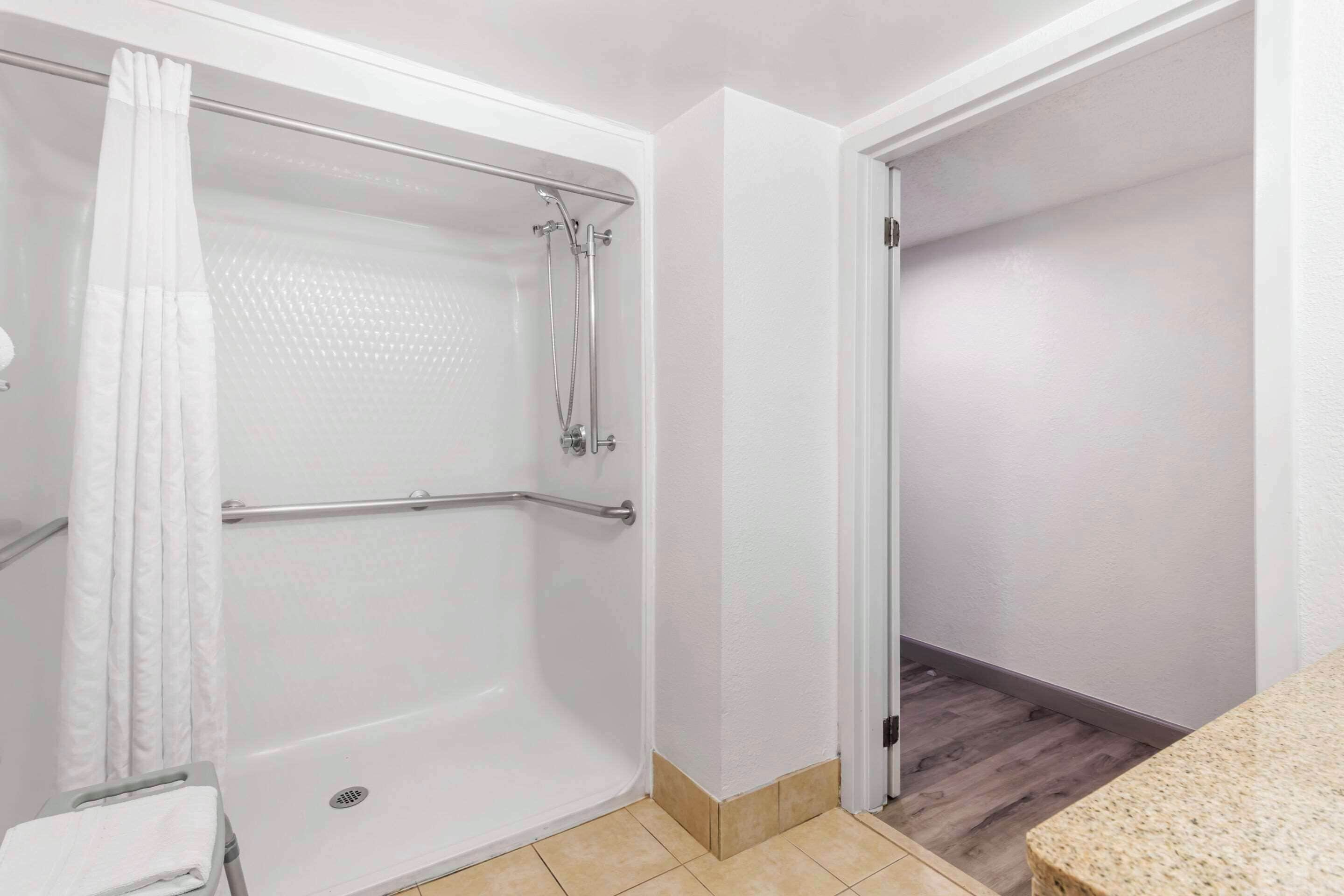 A bathroom with a shower, a toilet, and a sink.