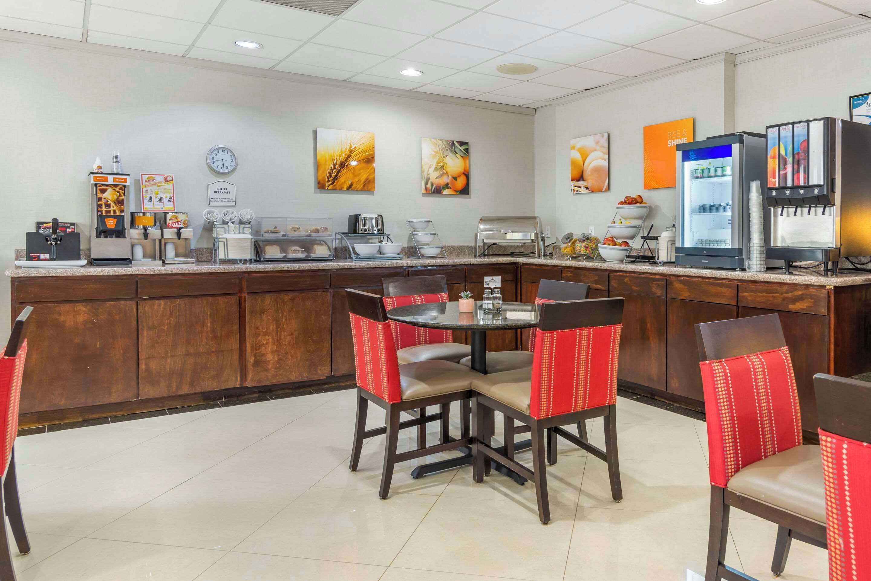 Ein Hotelrestaurant mit Tresen, Kaffeeautomaten und Sitzgelegenheiten.