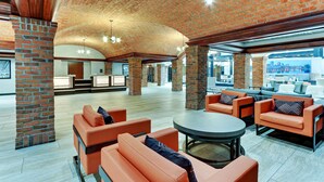 A spacious lobby with orange seating, a round table, and a brick ceiling. - Drury Plaza Hotel St. Paul Downtown (St. Paul)