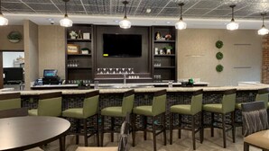 A modern bar area with a flat-screen TV, bar stools, and a counter. - Drury Plaza Hotel St. Paul Downtown (St. Paul)