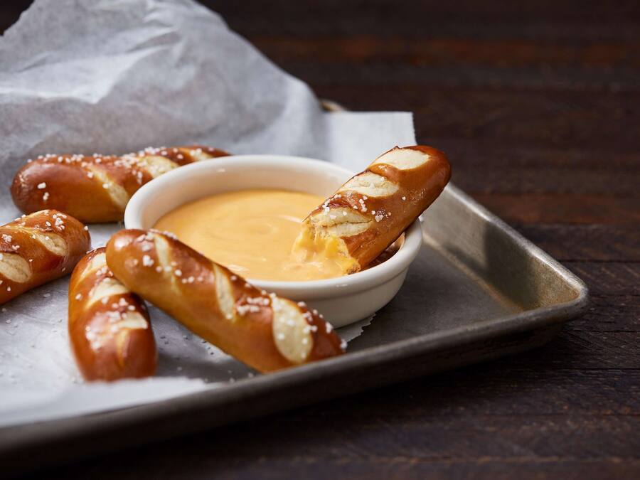 Pretzels with a dipping sauce on a tray.