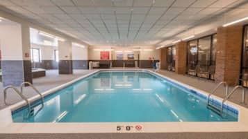 Una piscina interior con agua cristalina, una marca de profundidad de 1,5 metros y un techo de azulejos.