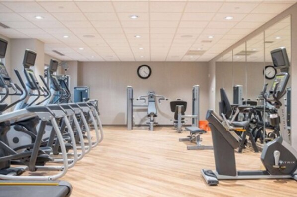 A gym with multiple treadmills, ellipticals, and weight machines.