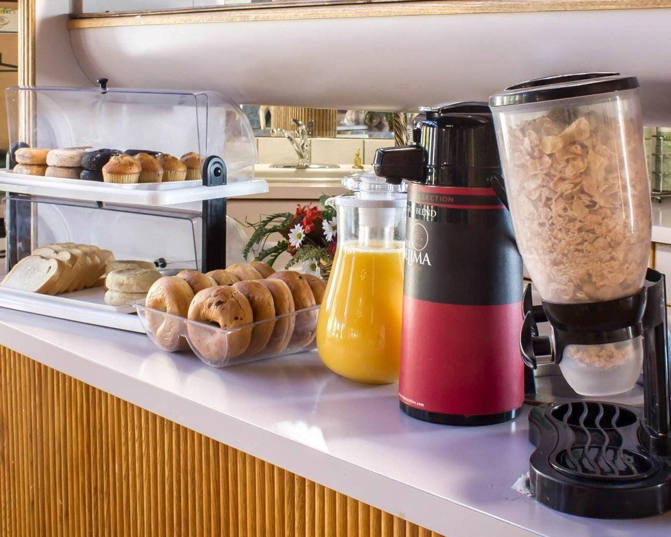 A breakfast buffet with pastries, a blender, and a coffee maker.