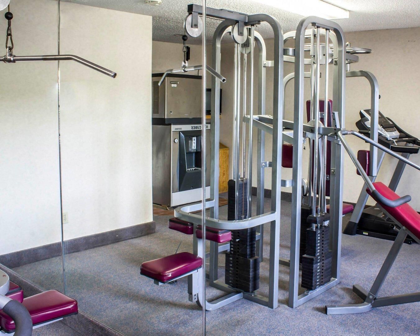 A gym with weight machines, a water dispenser, and a treadmill.